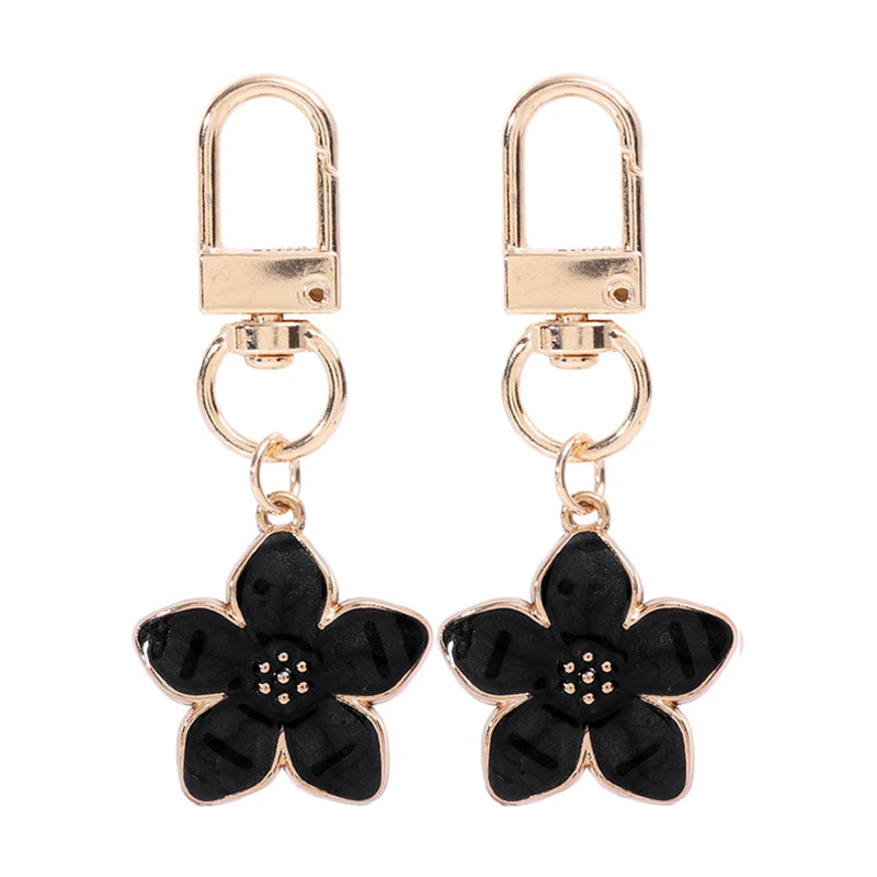 Un par de llaveros florales dorados con anillos divididos y unidos a un llavero.