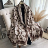 A brown and cream patterned luxury plaid cashmere feel scarf and shawl wrap displayed on a hanger.