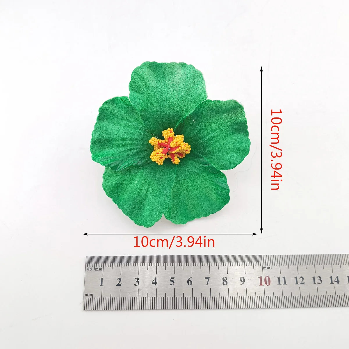 A vibrant green flower made of fabric is shown next to a ruler for scale.