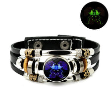 Bracelet en cuir noir avec perles argentées, accents dorés et une pierre bleu foncé avec des détails violets.