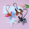 A collection of elegant horse pendant charms in various colors and materials, including leather, felt, and enamel.