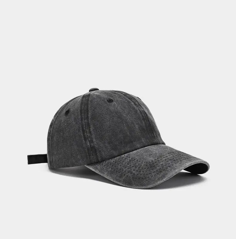 A dark gray washed cotton snapback cap shown from the side.
