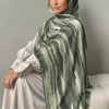Una mujer vistiendo un elegante pañuelo de hijab a rayas verdes y blancas con un top transparente.