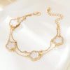Gold jewelry featuring five-leaf clover charms on a delicate chain anklet.