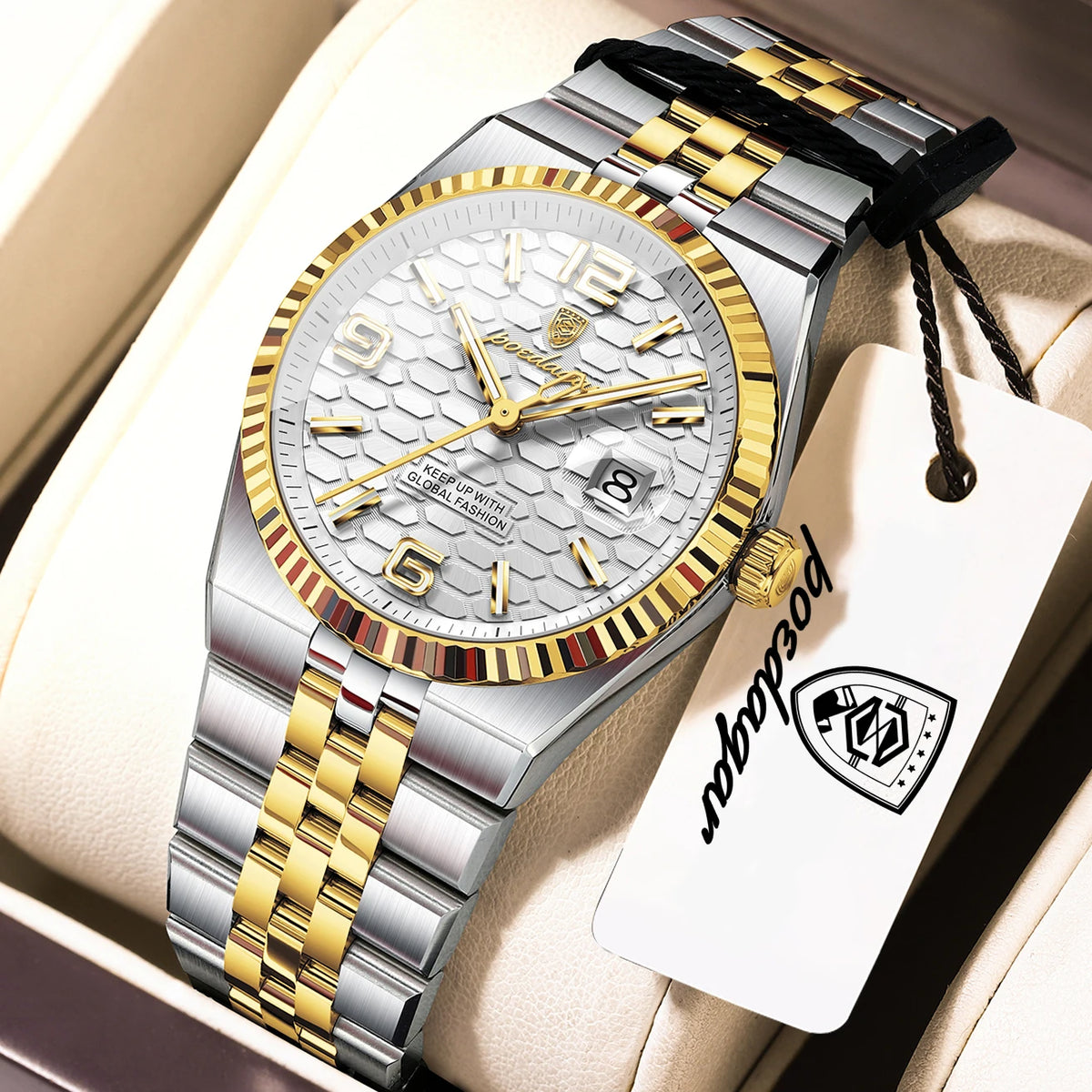 A silver and gold luxury quartz wristwatch with a textured dial and a black leather strap is displayed in a light-colored box