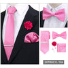 A set of pink men's formal tie and accessories including a necktie, bow tie, and pocket square on a black suit jacket.