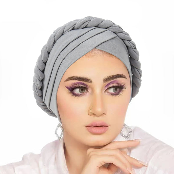 A woman wearing a gray triple crossed forehead hijab cap with purple eyeshadow.