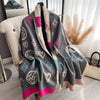 A gray and pink plaid cashmere feel scarf and shawl wrap draped over a chair.