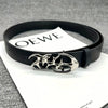 Black fashion belt with a silver skull buckle resting on a white card.