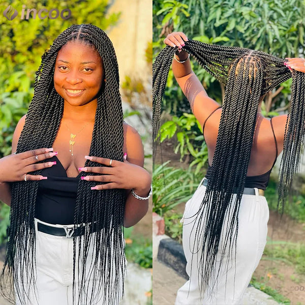 Una mujer con largas trenzas negras está sonriendo y posando al aire libre.