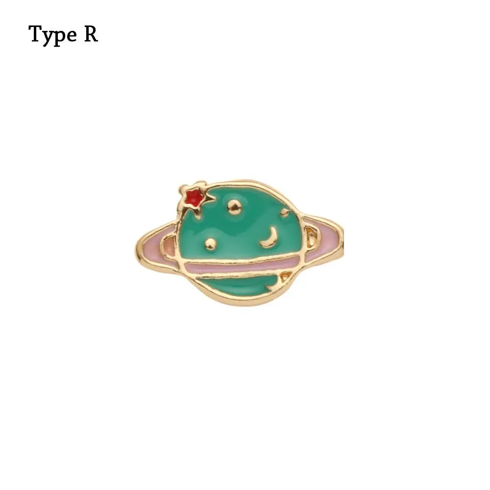 Un dije de esmalte verde redondo en forma de planeta con un engarce de metal tono dorado.