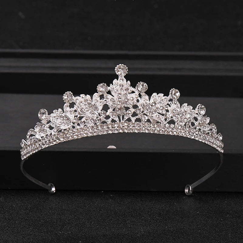 A sparkling crystal rhinestone bridal tiara headpiece displayed on a black surface.