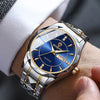 A close-up of a men's stainless steel quartz watch with a blue dial and gold accents worn on a wrist.