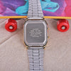 A stainless steel Casio watch with a silver band and gold accents is displayed against a colorful background.