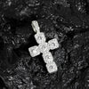 A sparkling rhinestone cross pendant necklace resting on a dark, textured surface.