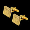 A pair of gold-toned square cufflink studs with a textured finish against a black background.