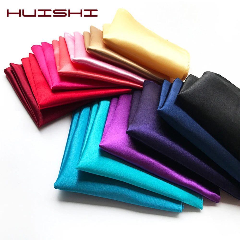 Eine Sammlung gefalteter Satin-Einstecktücher in verschiedenen Farben wie rot, pink, gold und blau.