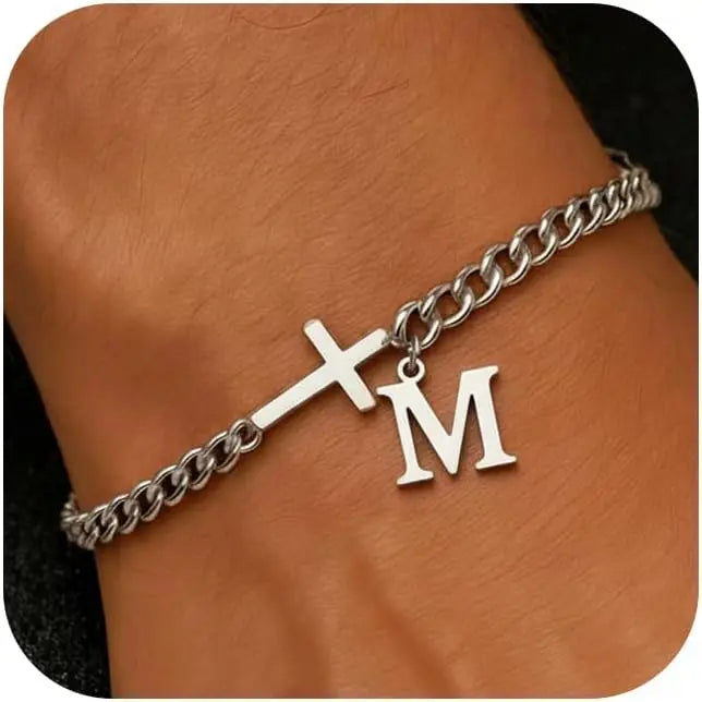 A silver stainless steel cross Cuban chain bracelet with a monogram initial charm worn on a wrist.