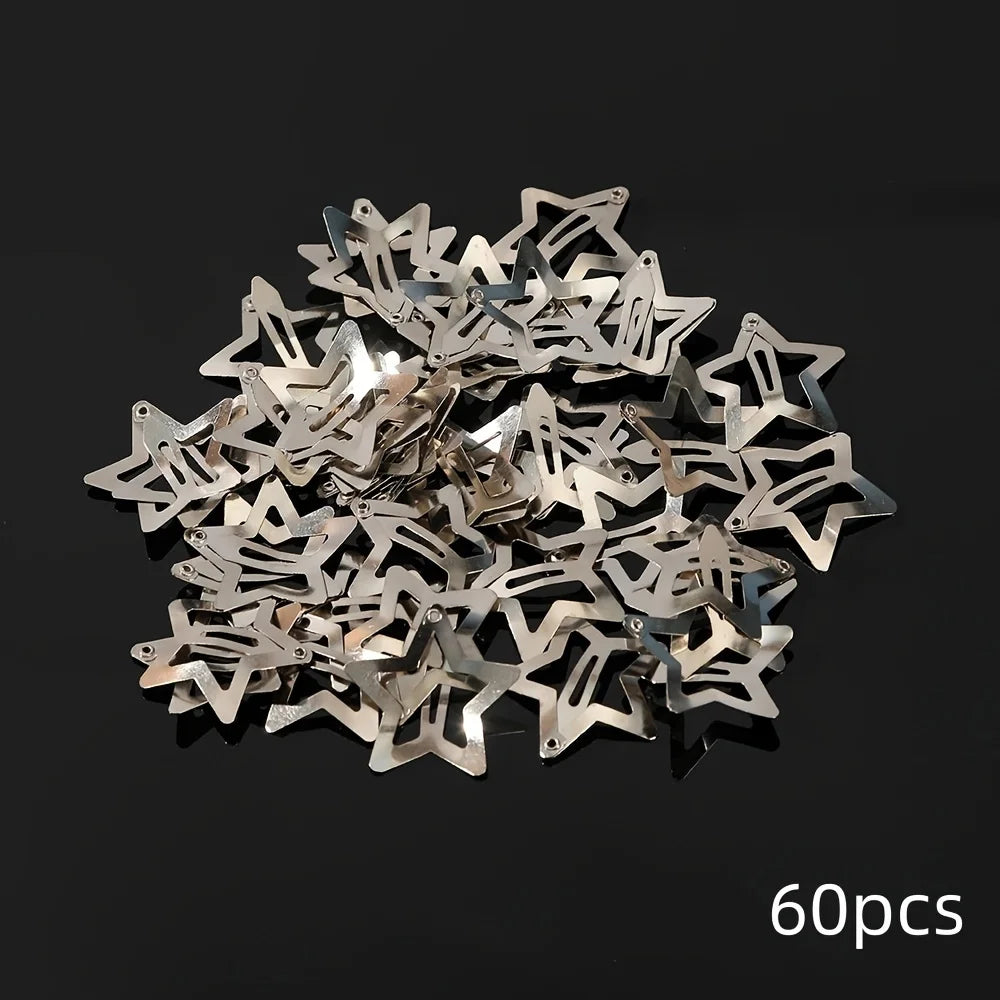 A pile of silver star metal snap hair clips on a dark background.