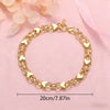 Gold heart charm bracelet made of 925 sterling silver for women displayed on a pink background