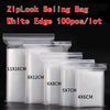 A collection of white edge ZipLock sealing bags in various sizes stacked on a dark surface.