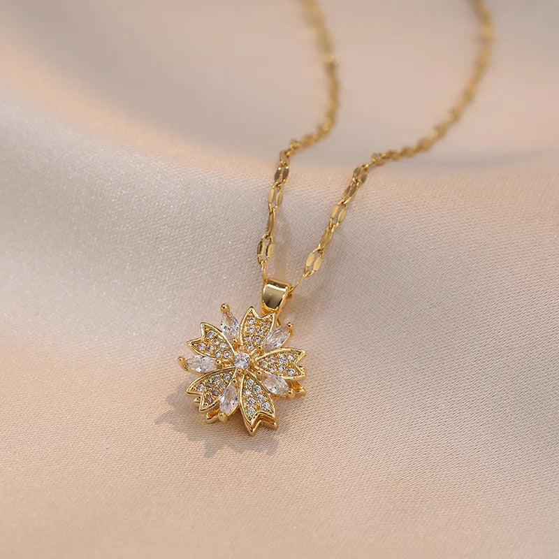 Collier délicat en or avec pendentif en forme de fleur incrusté de petites pierres claires.