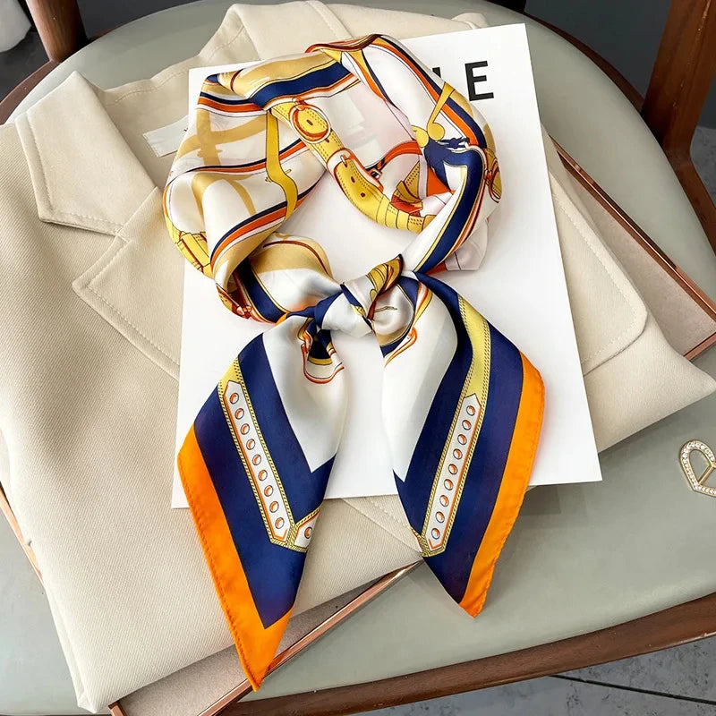 A silk scarf featuring a pattern of yellow, white, and blue stripes tied into a square shawl.