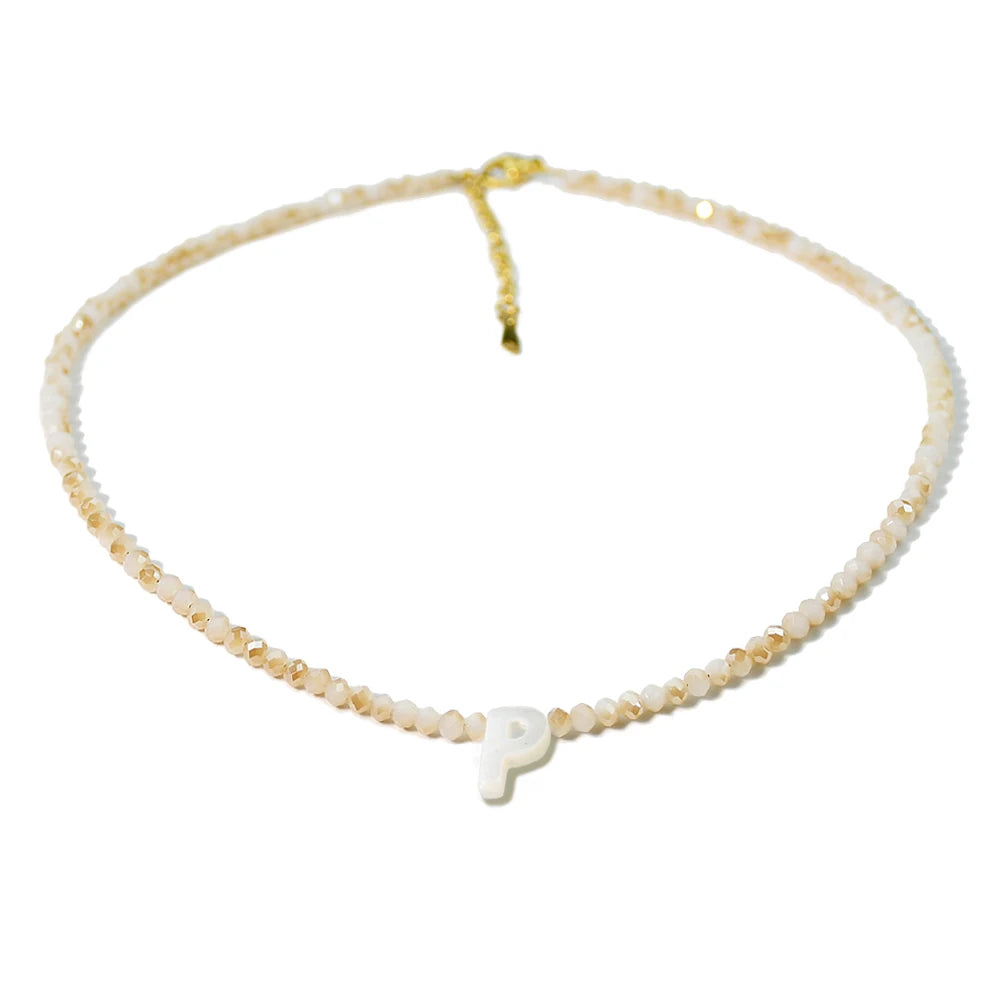 A delicate necklace made of mother of pearl beads with crystal accents, featuring a letter P pendant.