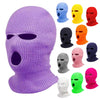 Lila Strick-Balaclava-Maske mit Augenöffnungen und verschiedenen farbigen Masken ausgestellt.