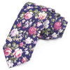 Une pile de nœuds papillon en coton à imprimé floral élégants dans des tons de rose, violet et vert.