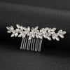 Accessoire de coiffure pour mariée en cristal, avec des feuilles scintillantes et des pointes métalliques fines.