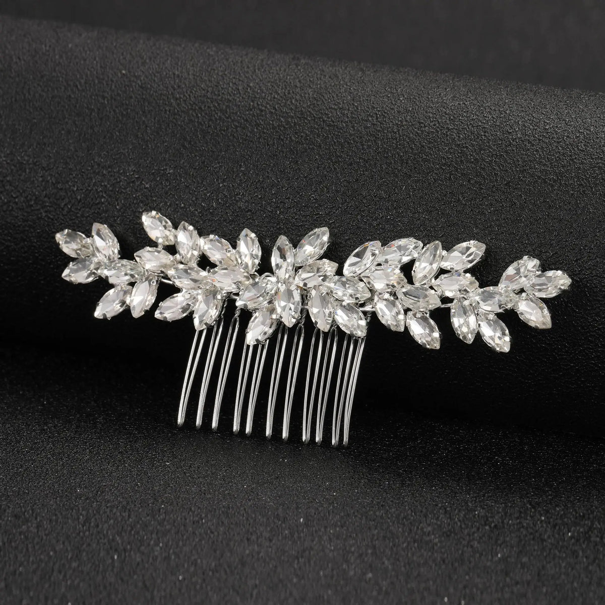 Accessoire de coiffure pour mariée en cristal, avec des feuilles scintillantes et des pointes métalliques fines.