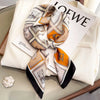 A folded fashion silk scarf and headband set featuring white, beige, and orange patterns on a white background.