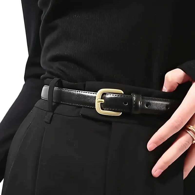 A close-up of a black PU fashion belt with a gold buckle worn on a black suit jacket.