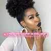 A woman with natural hair styled in an afro puff drawstring ponytail extension looking towards the camera.