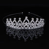 A sparkling crystal hair crown for women displayed on a dark reflective surface.