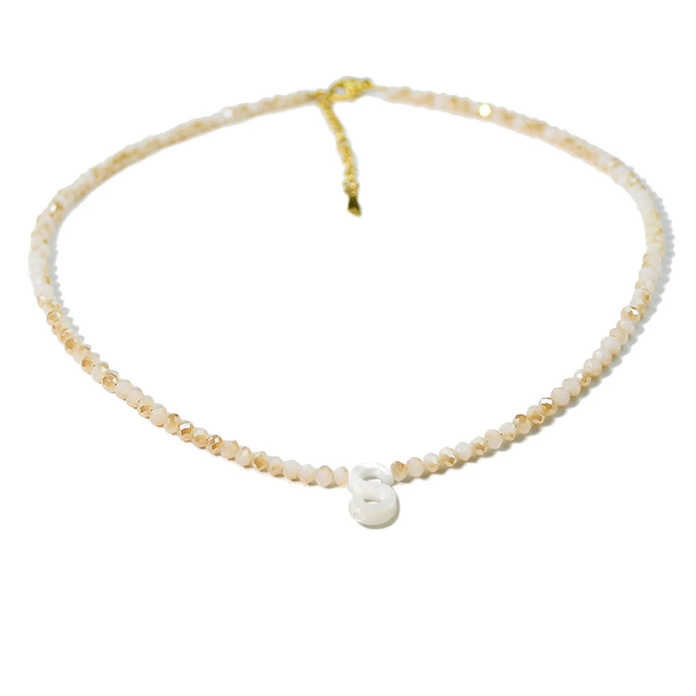 A delicate necklace made of mother of pearl beads with small crystal accents.