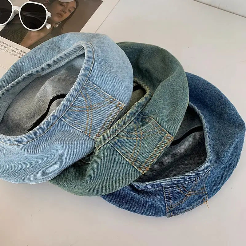 Two folded retro washed cotton denim beret hats in blue and teal colors