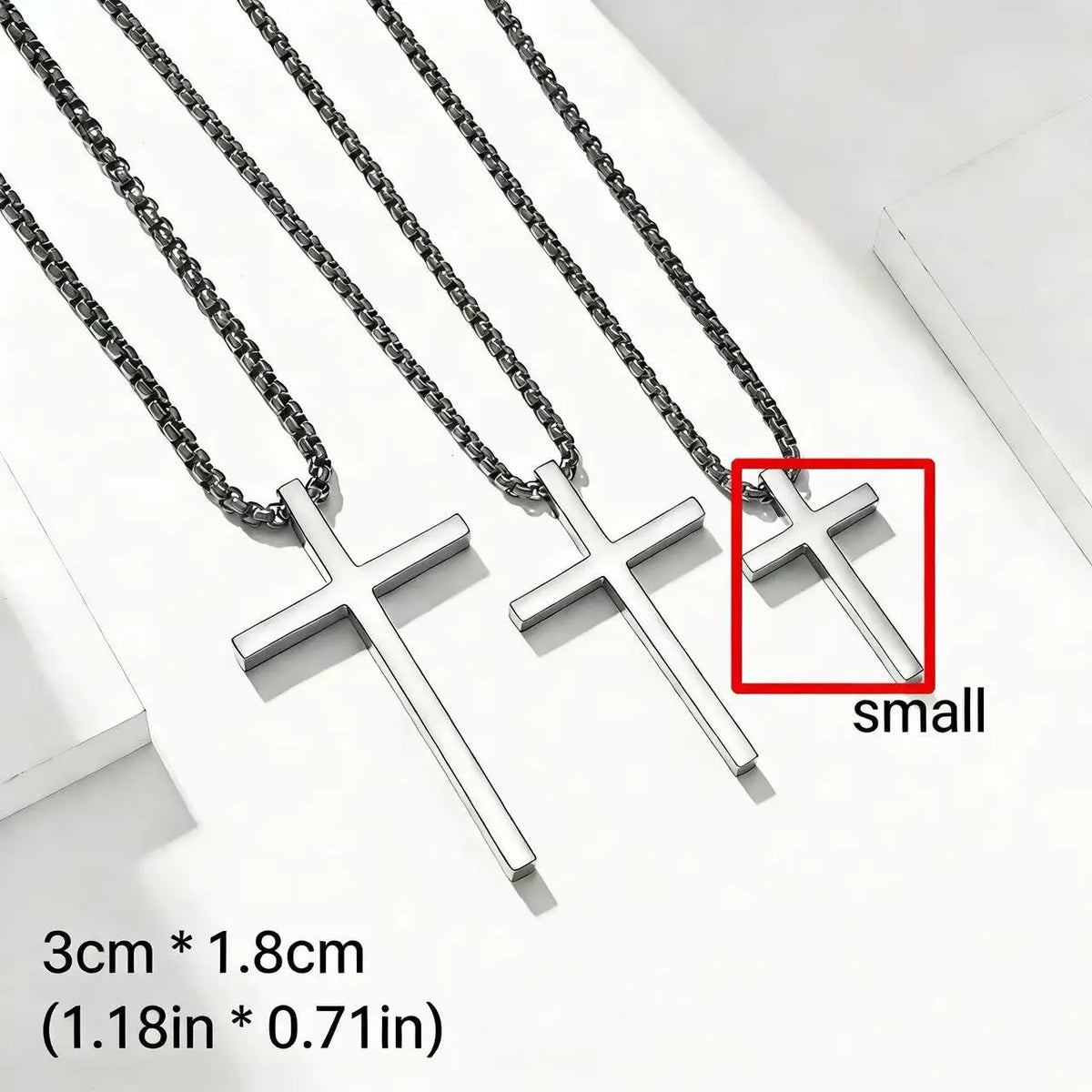 Silver stainless steel cross pendant necklace displayed on a white background with a size reference.