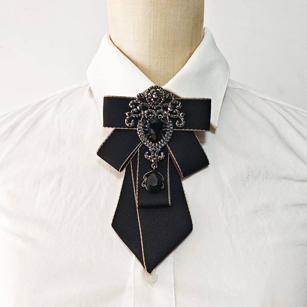 A black handcrafted tie with diamond embellishments worn on a white collared shirt.