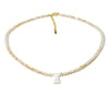 A delicate necklace made of mother of pearl beads with crystal accents and a small charm.