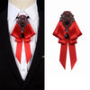 A red satin bow tie with black rhinestone embellishments worn on a white shirt collar.