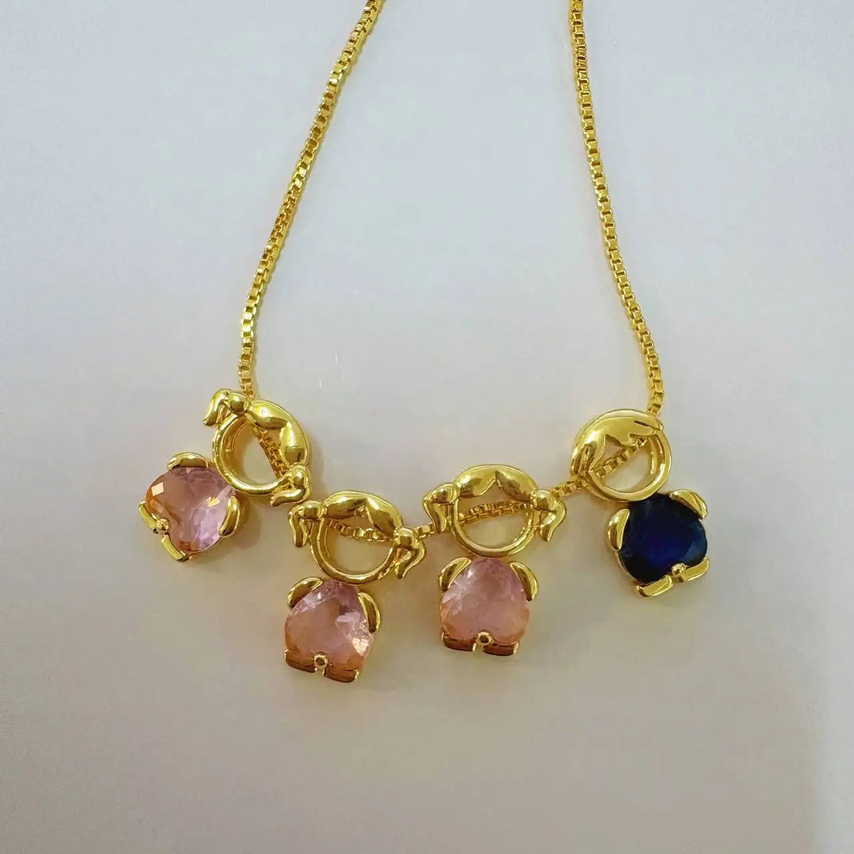 Goldenes Herz-Anhänger-Halskette mit rosa und blauen Edelsteinen an einer zarten Kette.