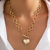 Nahaufnahme einer 18k-Gold-Gestickten-Kreuz-Anhänger-Kette, getragen um den Hals, vor hellem Hintergrund.