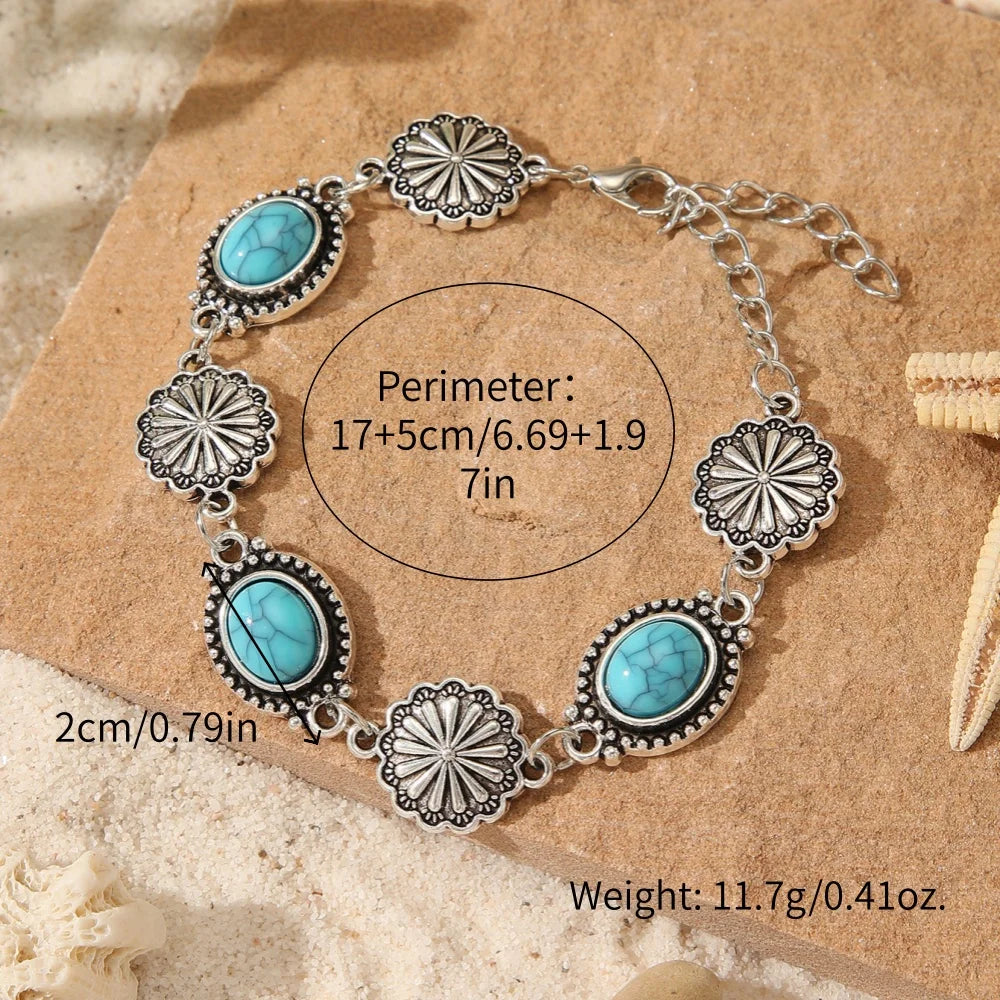 Silver and turquoise beaded necklace bracelet set with flower motifs on a natural brown background