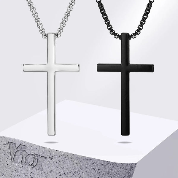 A pair of stainless steel cross necklaces, one silver and one black, displayed on a light gray surface.