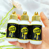 Drei Glasflaschen Luxfume Lace Glue Spray in einer Hand vor weißem Hintergrund