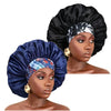 A woman models a black satin sleep bonnet with an elastic band and a floral patterned fabric.