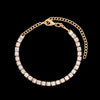A gold crystal Cuban link anklet for women displayed against a black background.