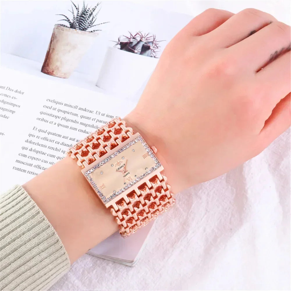 A close-up of a fashion quartz diamond watch with a gold stainless steel bracelet worn on a wrist.